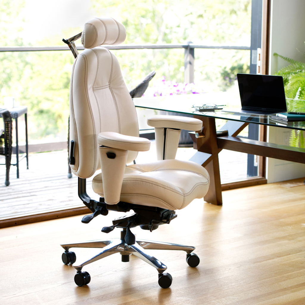 A 2490 Executive Lifeform Chairs, cream leather ergonomic office chair with a mid back and headrest sits in a sunlit home office next to a glass desk.